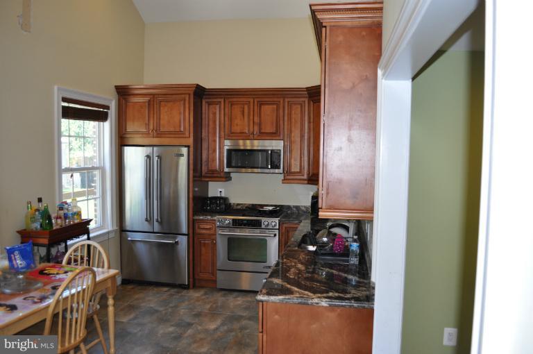 2916 Weisman Road Silver Spring, MD 20902 - Photo 2 of 19 a kitchen with stainless steel appliances granite countertop a refrigerator stove and sink
