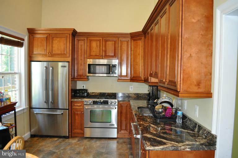 2916 Weisman Road Silver Spring, MD 20902 - Photo 16 of 19 a kitchen with stainless steel appliances granite countertop a refrigerator stove and sink