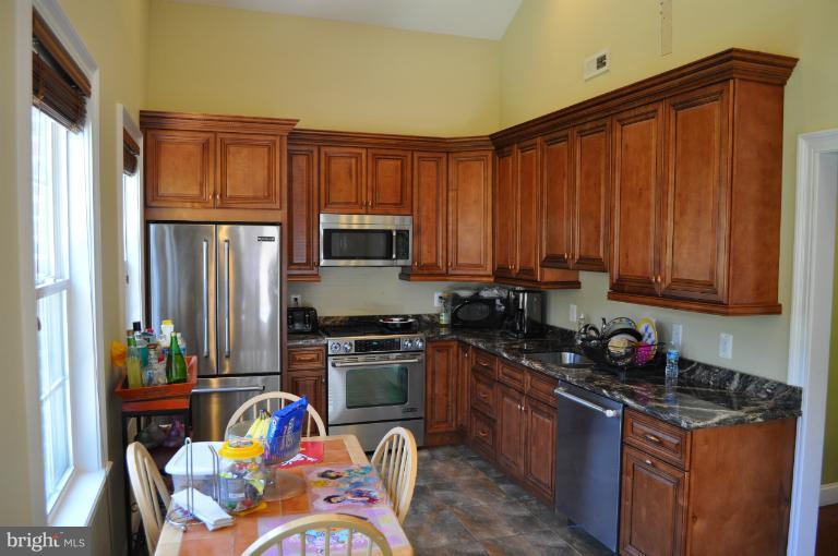 2916 Weisman Road Silver Spring, MD 20902 - Photo 8 of 19 a kitchen with stainless steel appliances granite countertop a refrigerator stove and sink