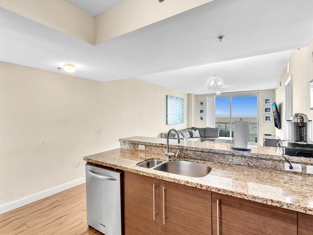 2681 North Flamingo Road, Unit 2104S Fort Lauderdale, FL 33323 - Photo 11 of 99 a kitchen with granite countertop a sink a stove and cabinets