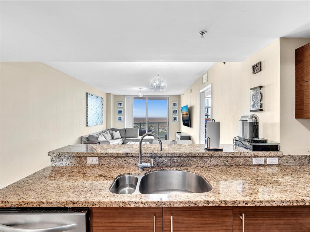 2681 North Flamingo Road, Unit 2104S Fort Lauderdale, FL 33323 - Photo 10 of 99 a kitchen with granite countertop a sink and a counter top space