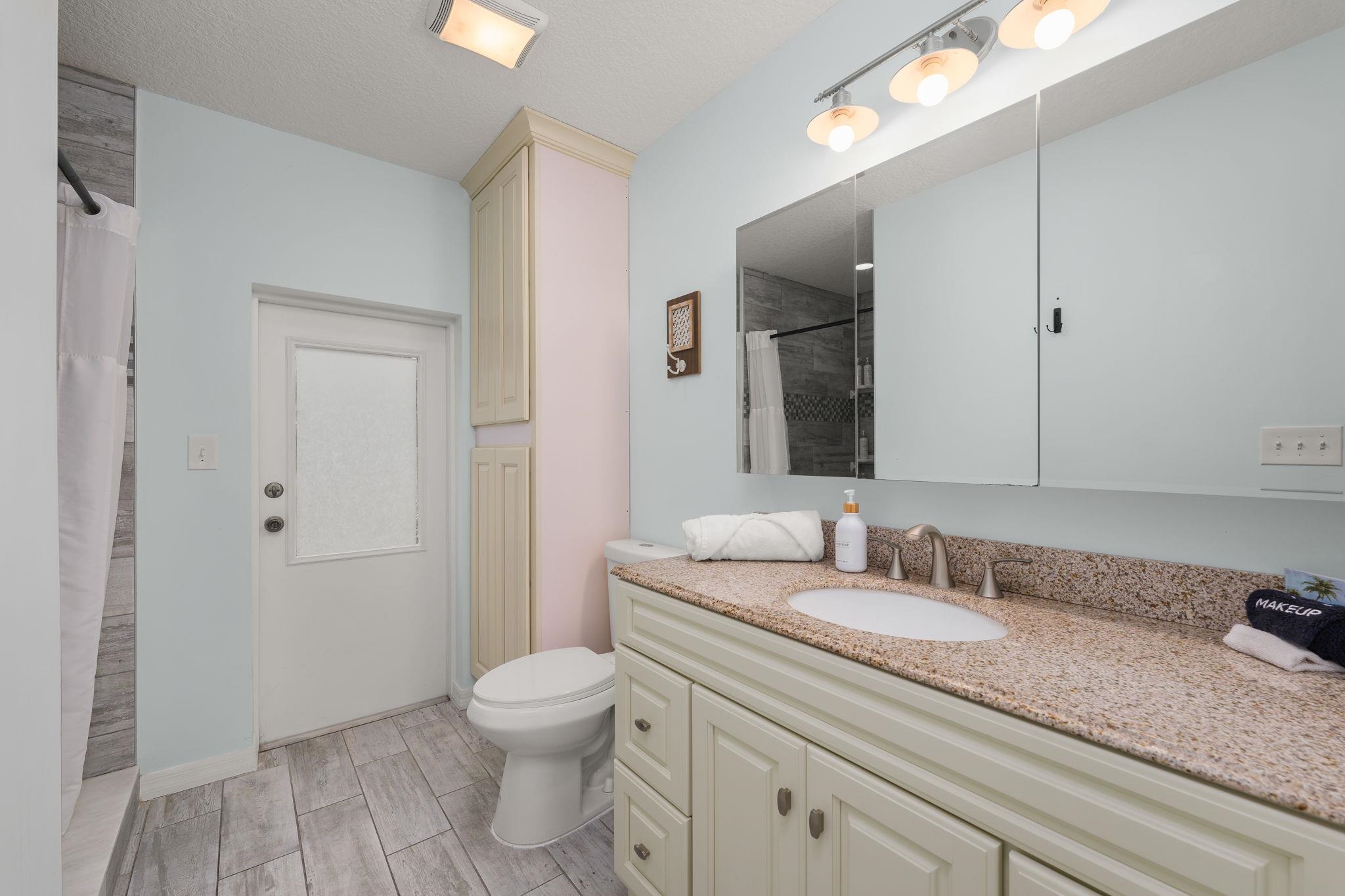 119 Menendez Road St. Augustine, FL 32080 - Photo 14 of 40 a bathroom with a granite countertop sink a toilet and a large mirror