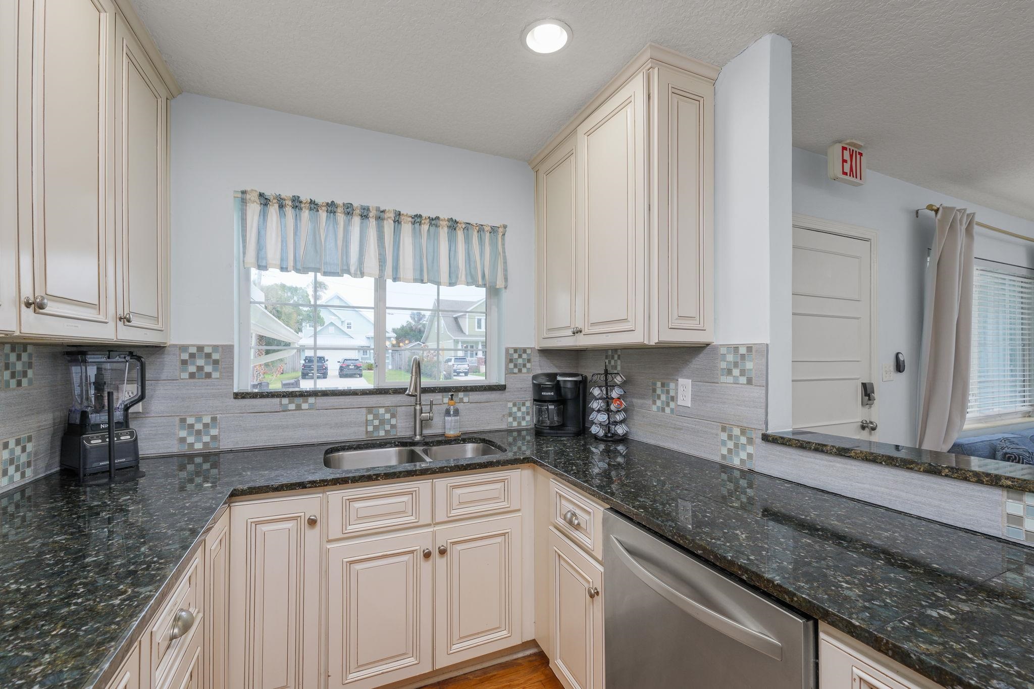 119 Menendez Road St. Augustine, FL 32080 - Photo 40 of 40 a kitchen with granite countertop white cabinets sink and window