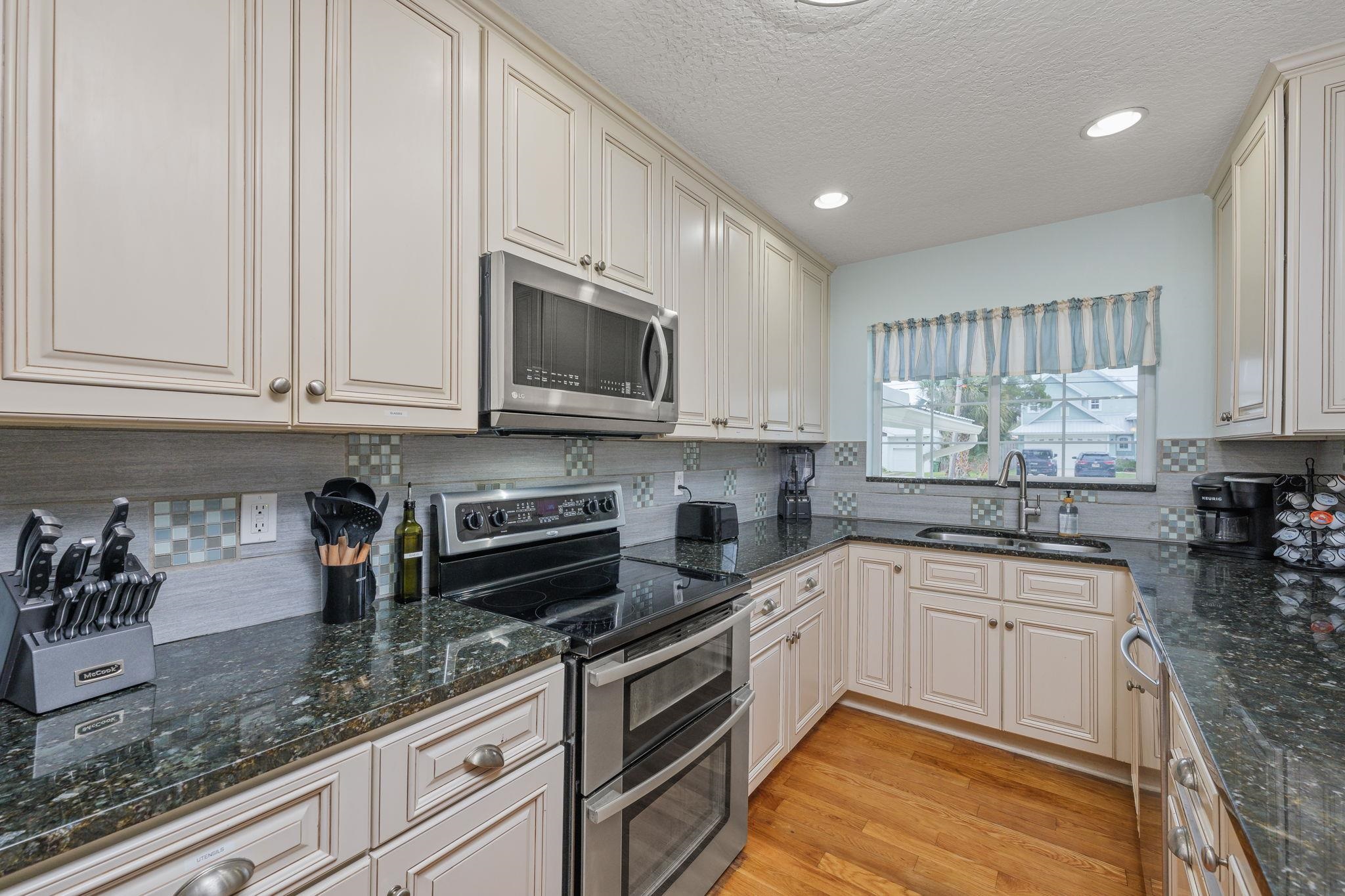 119 Menendez Road St. Augustine, FL 32080 - Photo 8 of 40 a kitchen with granite countertop white cabinets and white stainless steel appliances