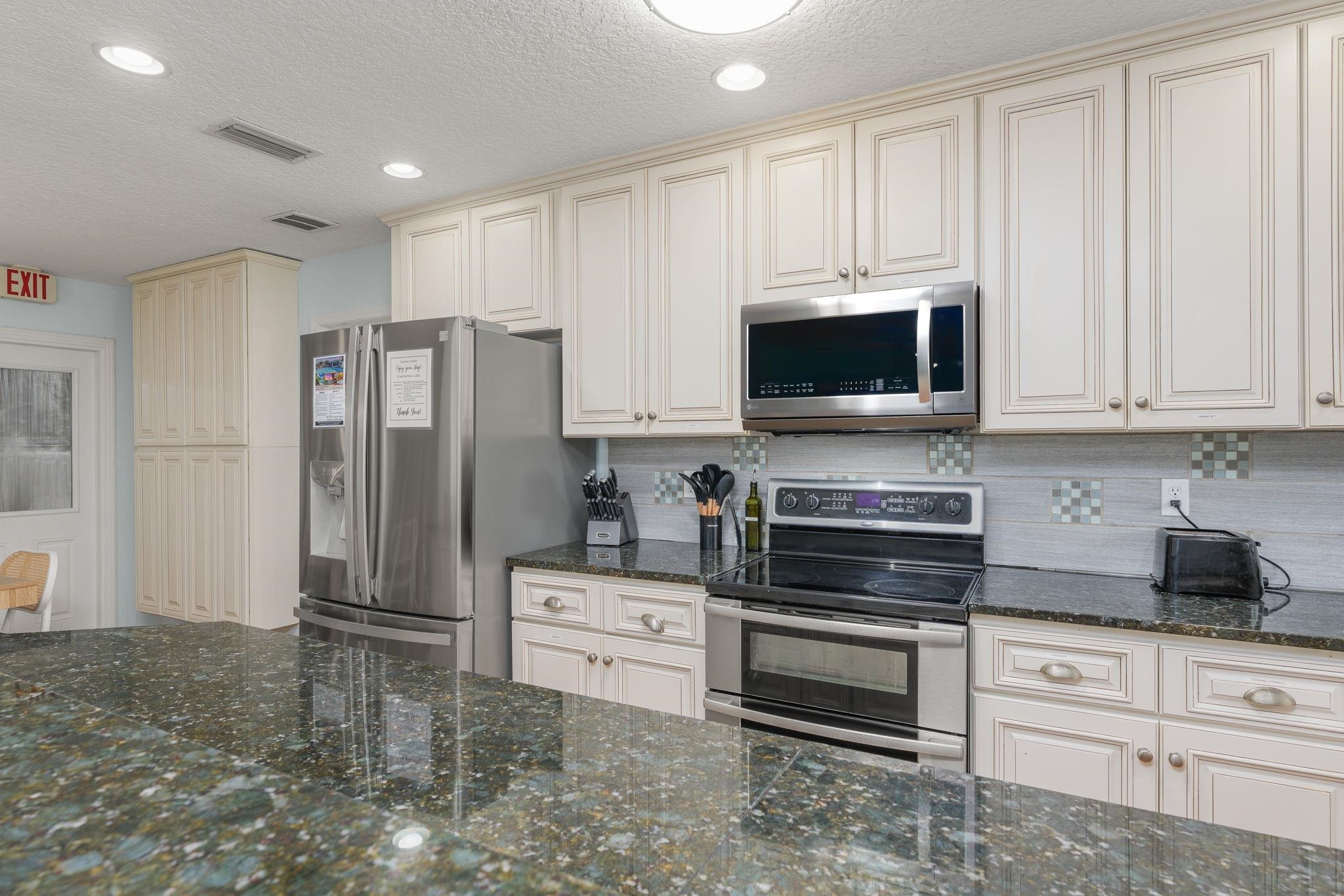 119 Menendez Road St. Augustine, FL 32080 - Photo 9 of 40 a kitchen with stainless steel appliances white cabinets and a stove top oven