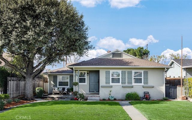 a front view of a house with a garden and plants