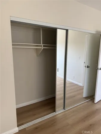 a view of walk in closet with wooden floor