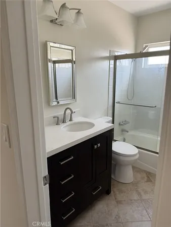 a bathroom with a toilet a sink a mirror and a shower
