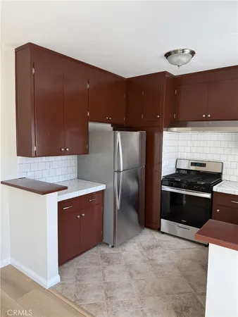 a kitchen with stainless steel appliances granite countertop a refrigerator and a stove