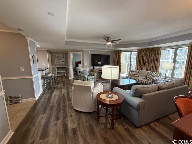9994 Beach Club Drive, Unit 1204 Myrtle Beach, SC 29572 - Photo 17 of 36 Living area featuring a tray ceiling, wood finished floors, a ceiling fan, and crown molding