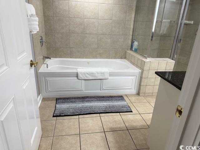 9994 Beach Club Drive, Unit 1204 Myrtle Beach, SC 29572 - Photo 28 of 36 Bathroom with light tile patterned floors, tile walls, vanity, and washtub / shower combination