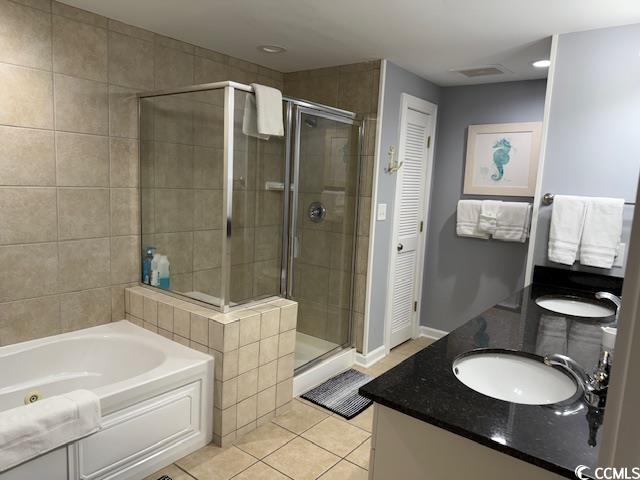 9994 Beach Club Drive, Unit 1204 Myrtle Beach, SC 29572 - Photo 29 of 36 Bathroom featuring light tile patterned floors, a closet, a stall shower, a bath, and double vanity