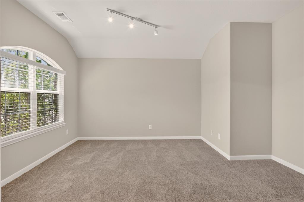 9105 Switchgrass Lane Forney, TX 75126 - Photo 3 of 20 Spacious room featuring vaulted ceilings, track lighting, and soft gray carpeting