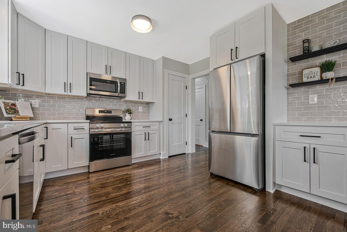 2105 Queens Chapel Road Mount Rainier, MD 20712 - Photo 3 of 33 a kitchen with stainless steel appliances a refrigerator sink and microwave