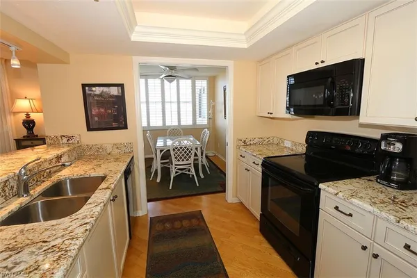 a kitchen with granite countertop a stove and a sink