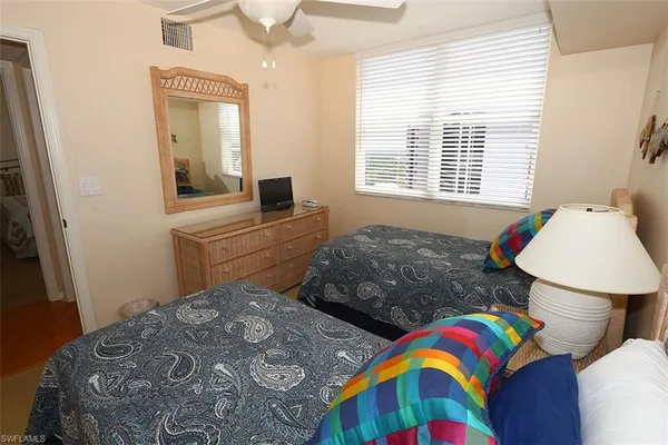 a bedroom with two beds and a dresser
