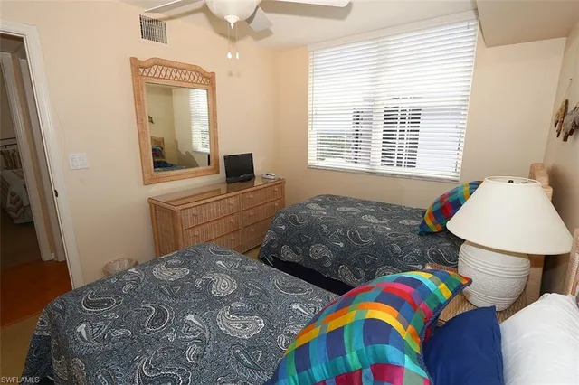 a bedroom with two beds and a dresser