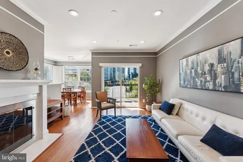 a living room with furniture a large window and a fireplace