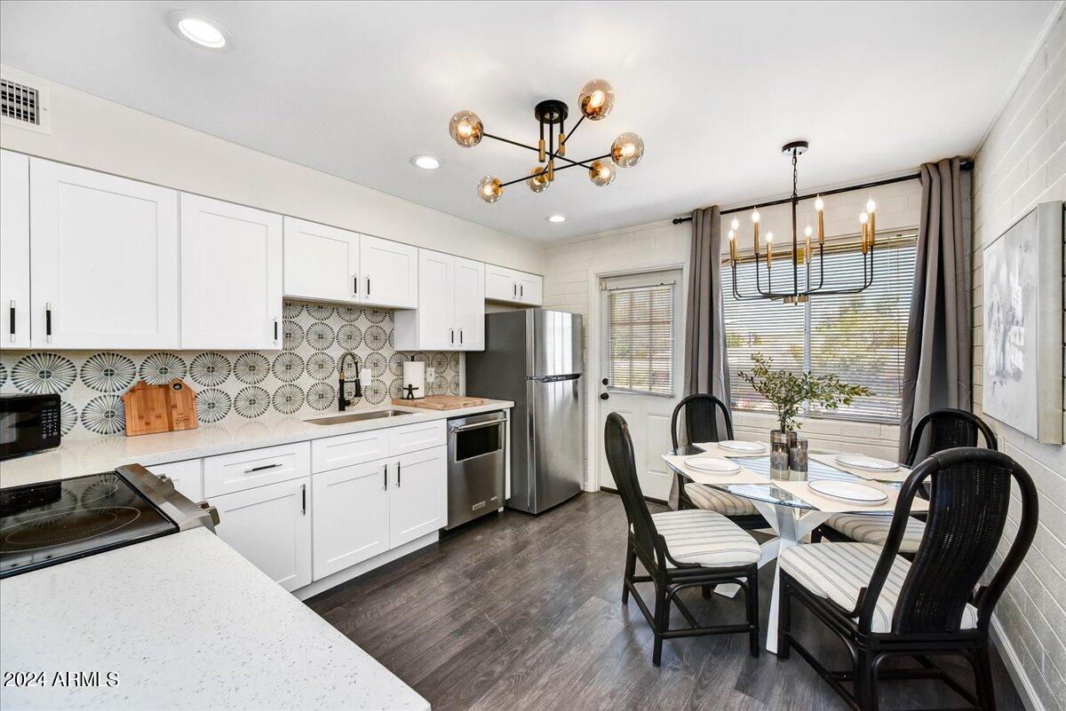 a kitchen with a dining table chairs stainless steel appliances and cabinets