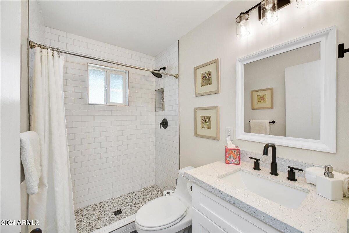 1908 West Berridge Lane, Unit 9 Phoenix, AZ 85015 - Photo 11 of 15 a bathroom with a sink a toilet a mirror and shower