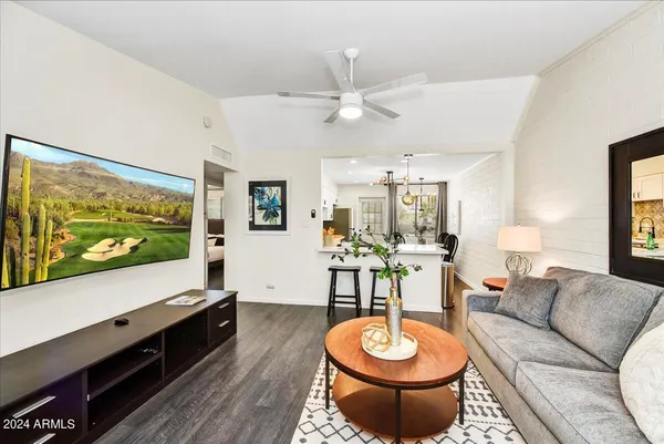 a living room with furniture a flat screen tv and a large window