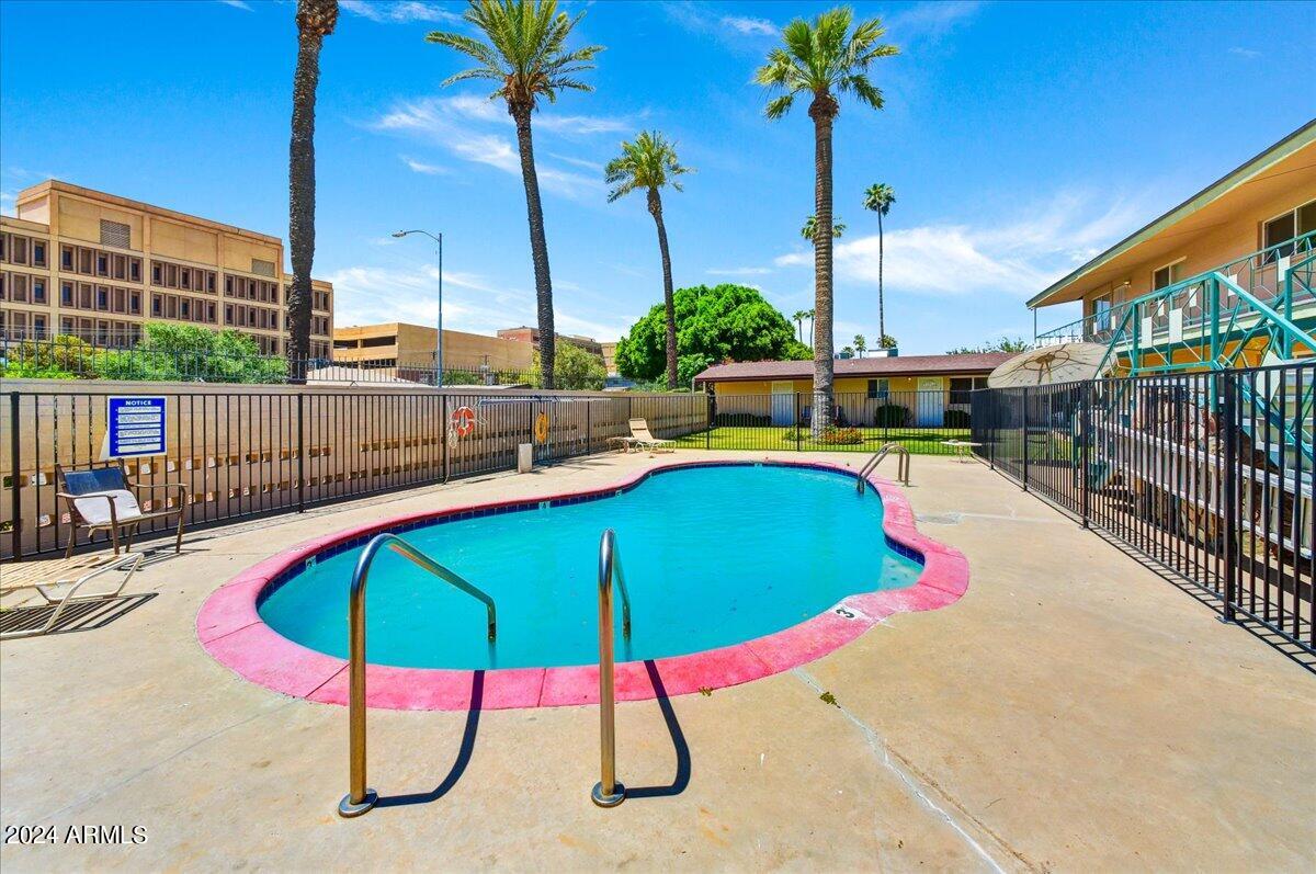 1908 West Berridge Lane, Unit 9 Phoenix, AZ 85015 - Photo 14 of 15 a view of a swimming pool with a chair and tables