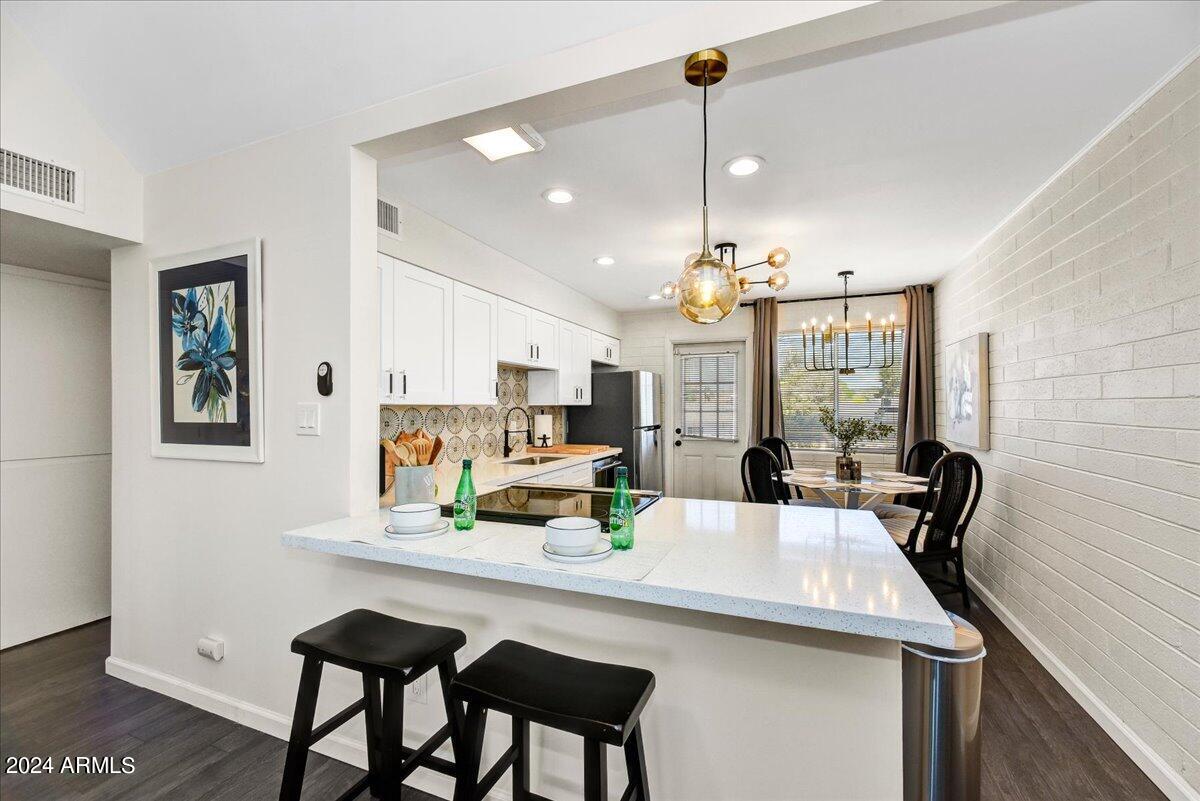 1908 West Berridge Lane, Unit 9 Phoenix, AZ 85015 - Photo 5 of 15 a view of a dining room with furniture and chandelier