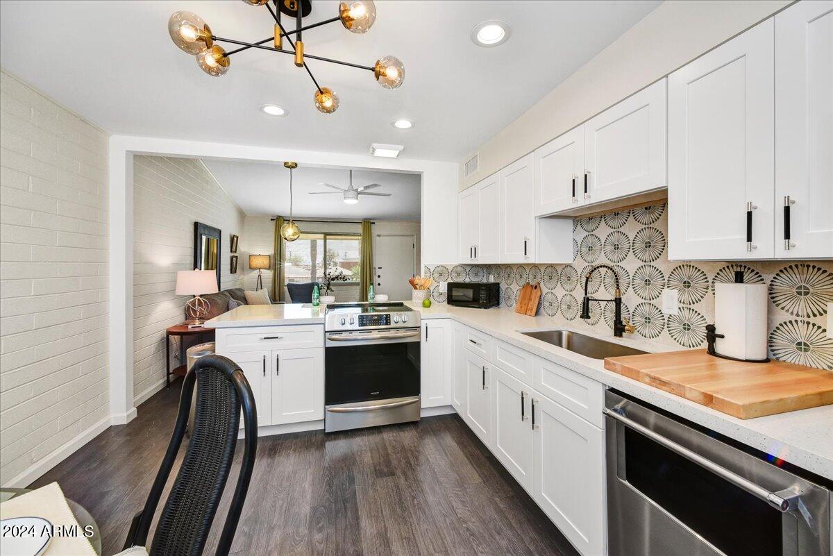 1908 West Berridge Lane, Unit 9 Phoenix, AZ 85015 - Photo 8 of 15 a kitchen with kitchen island granite countertop a sink appliances cabinets and a counter top space