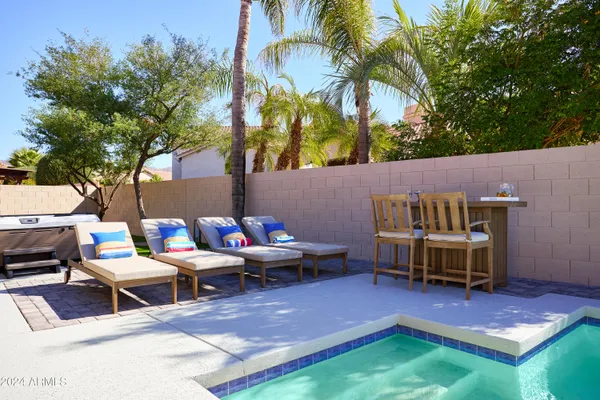 a backyard of a house with barbeque oven table and chairs