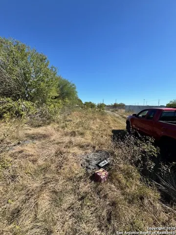 a view of a yard with wooden fence
