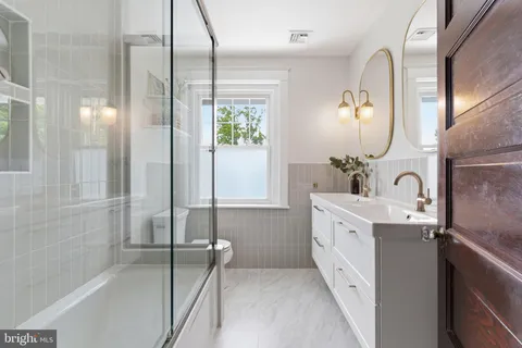 a spacious bathroom with a double vanity sink a mirror and a shower