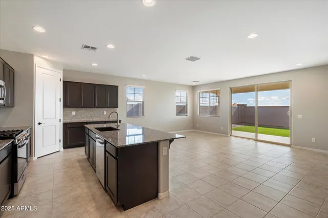 a kitchen with stainless steel appliances granite countertop a refrigerator a sink and a stove