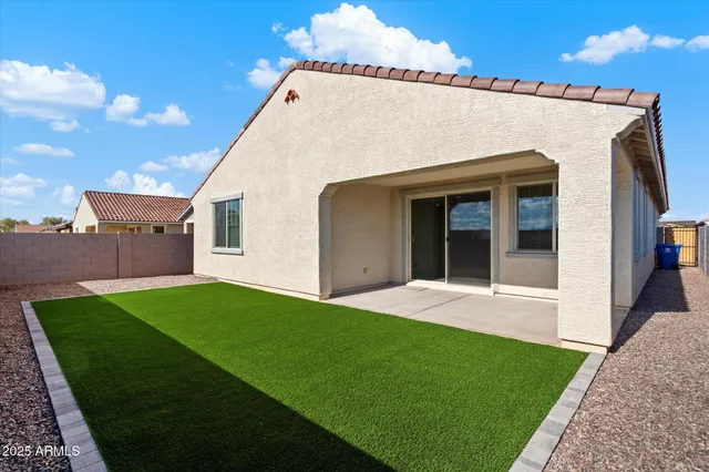 a view of a white house next to a yard