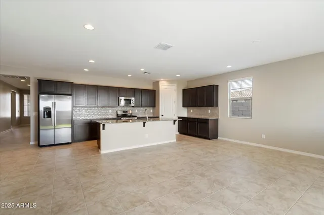 a large kitchen with a large counter top stainless steel appliances and cabinets