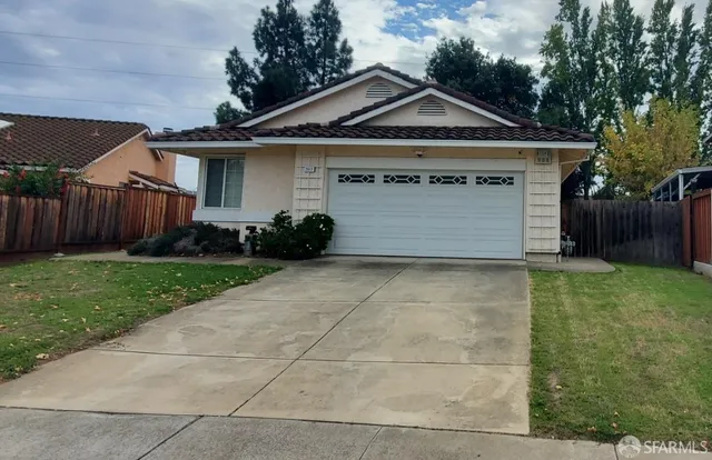 a front view of a house with a garden and garage