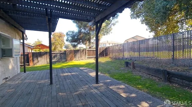 a view of swimming pool with wooden deck and a backyard