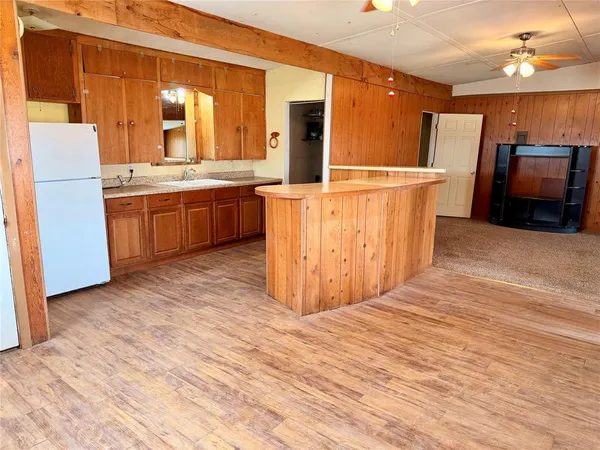 a view of kitchen with wooden floor and electronic appliances