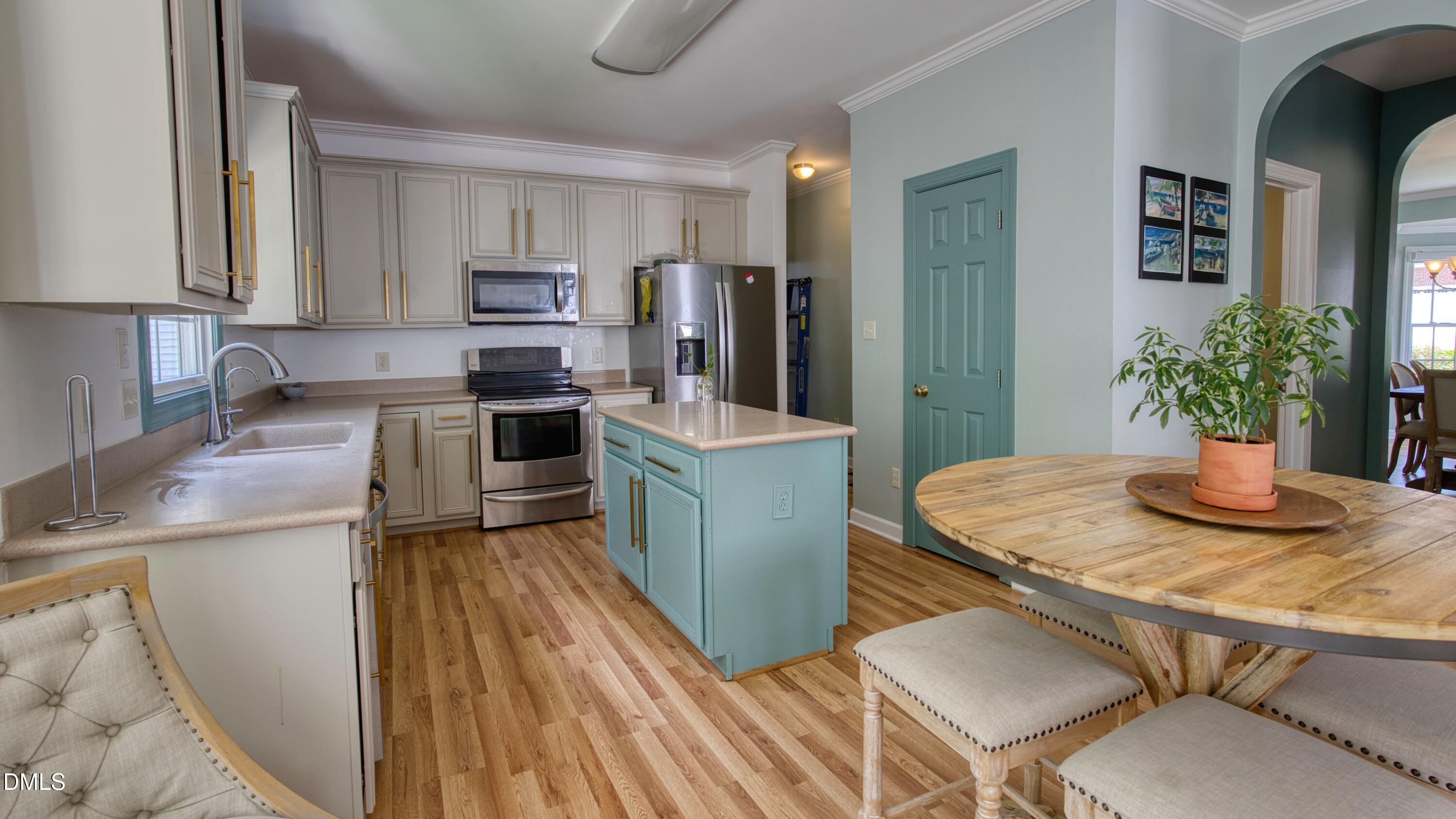 7 Monteith Court Durham, NC 27713 - Photo 24 of 44 a kitchen with stainless steel appliances kitchen island granite countertop a refrigerator a stove top oven a sink dishwasher and dining table with wooden floor