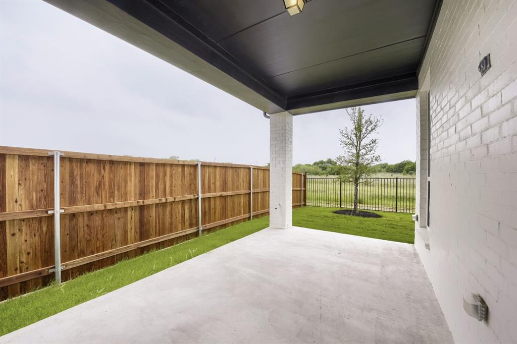 733 Red Cedar Road Haslet, TX 76052 - Photo 27 of 28 Covered patio with a concrete surface, white painted brick exterior, and a dark soffit