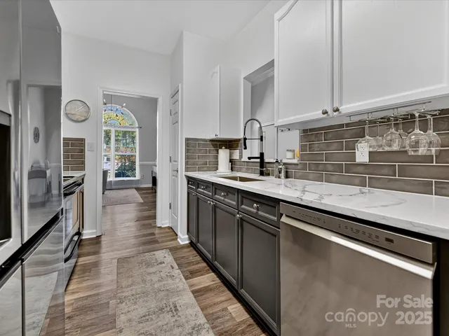 a large kitchen with granite countertop a sink dishwasher stove and cabinets