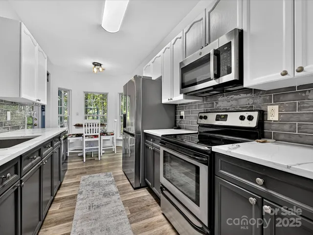 a kitchen with stainless steel appliances a stove microwave and sink