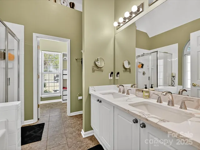 a spacious bathroom with a double vanity sink a mirror and a shower