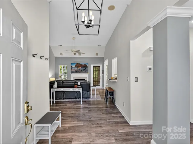 a view of a dining room with furniture a chandelier and wooden floor