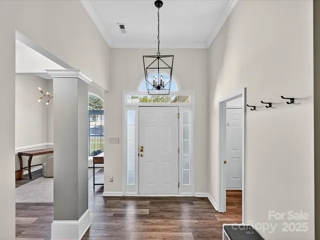 a view of a hallway with wooden floor and windows