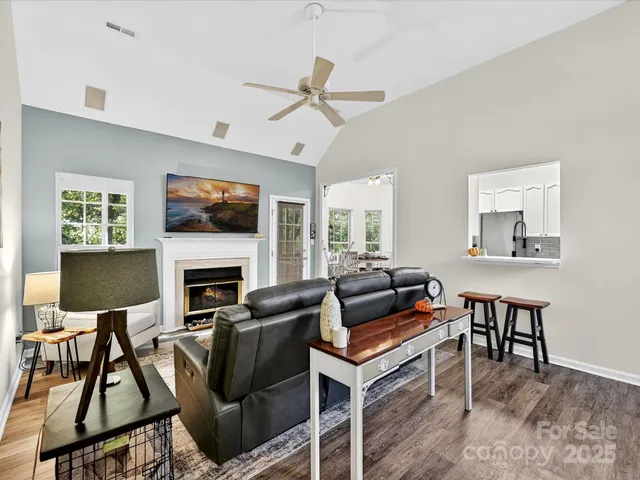 a living room with furniture a fireplace and a flat screen tv