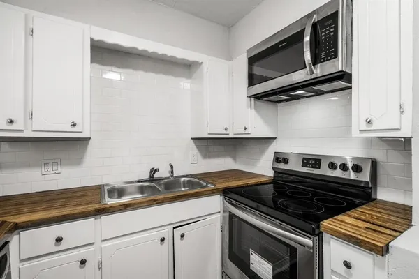 a kitchen with stainless steel appliances a stove a microwave and cabinets