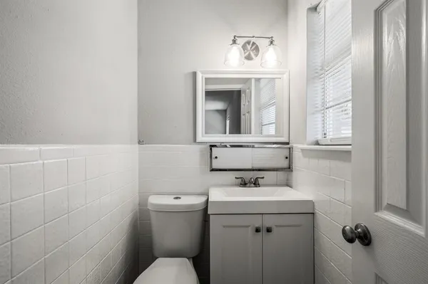 a bathroom with a sink a toilet and mirror