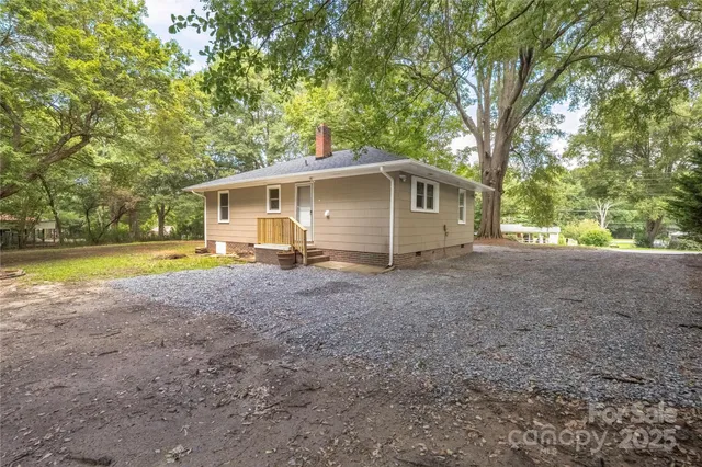 a view of a house with backyard and trees