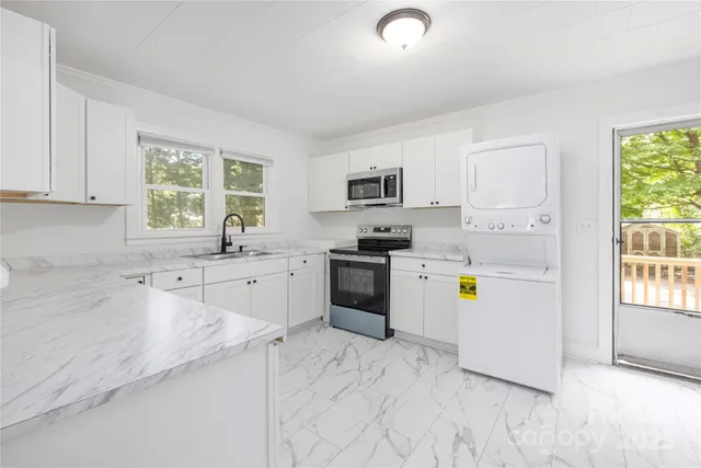 a kitchen with a sink a counter top space appliances and cabinets