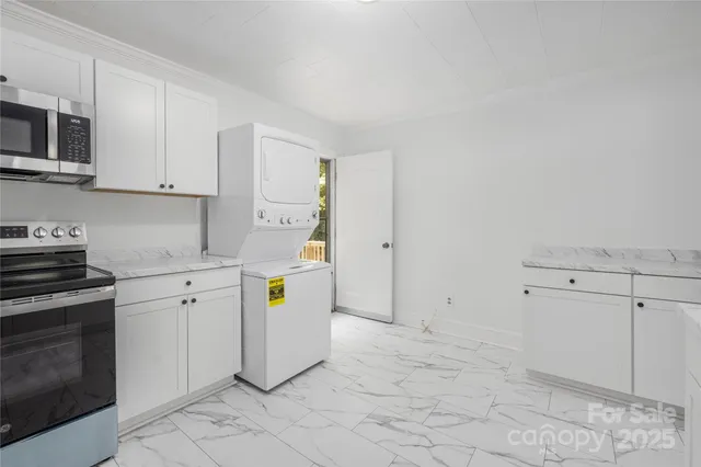 a utility room with cabinets washer and dryer